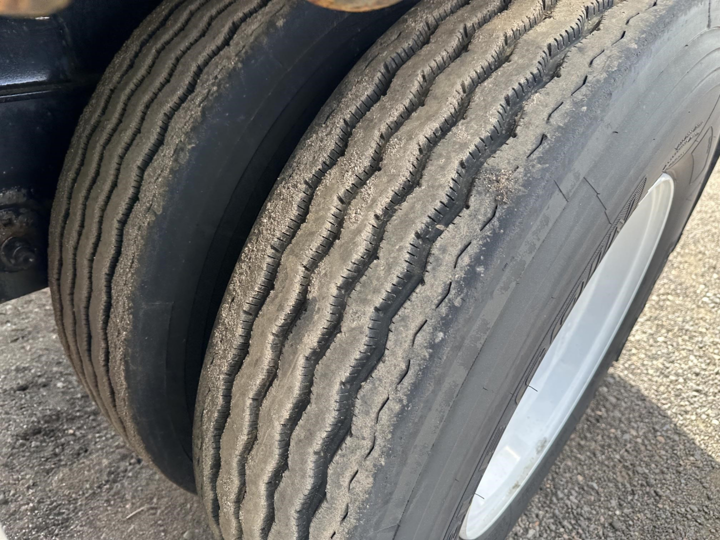 Tire and wheel on Fontaine spread air combo flatbed trailer showing tread pattern and dual tires.
