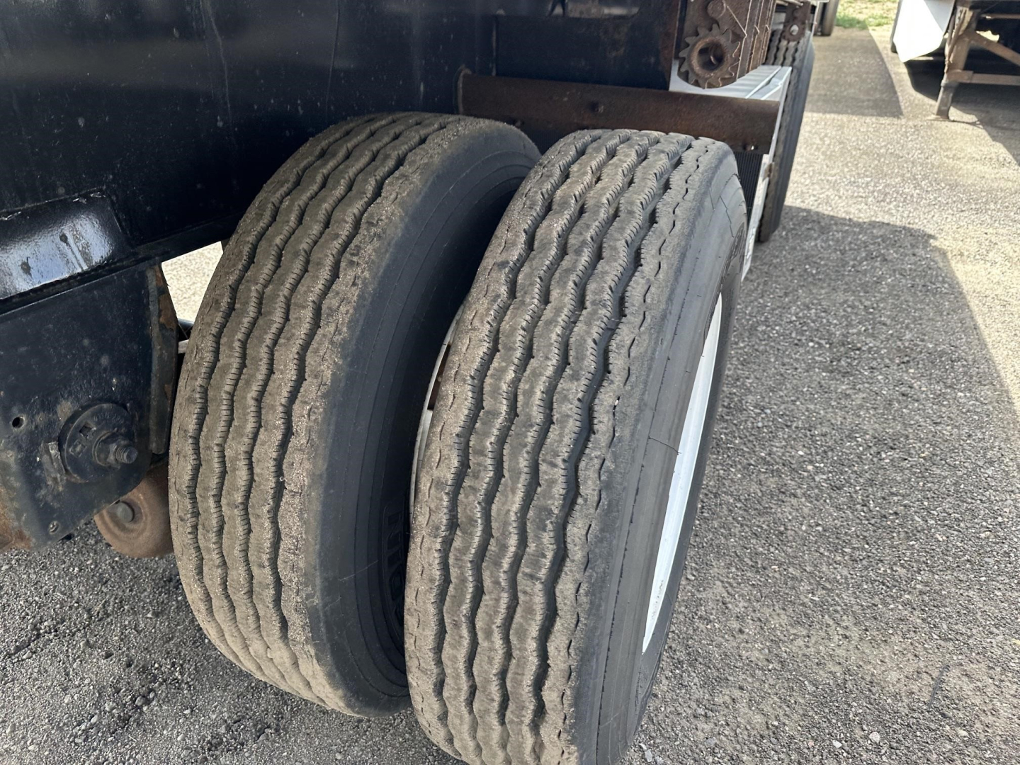 Fontaine spread air combo flatbed trailer dual rear axles with worn tires visible and部分 chrome rims.