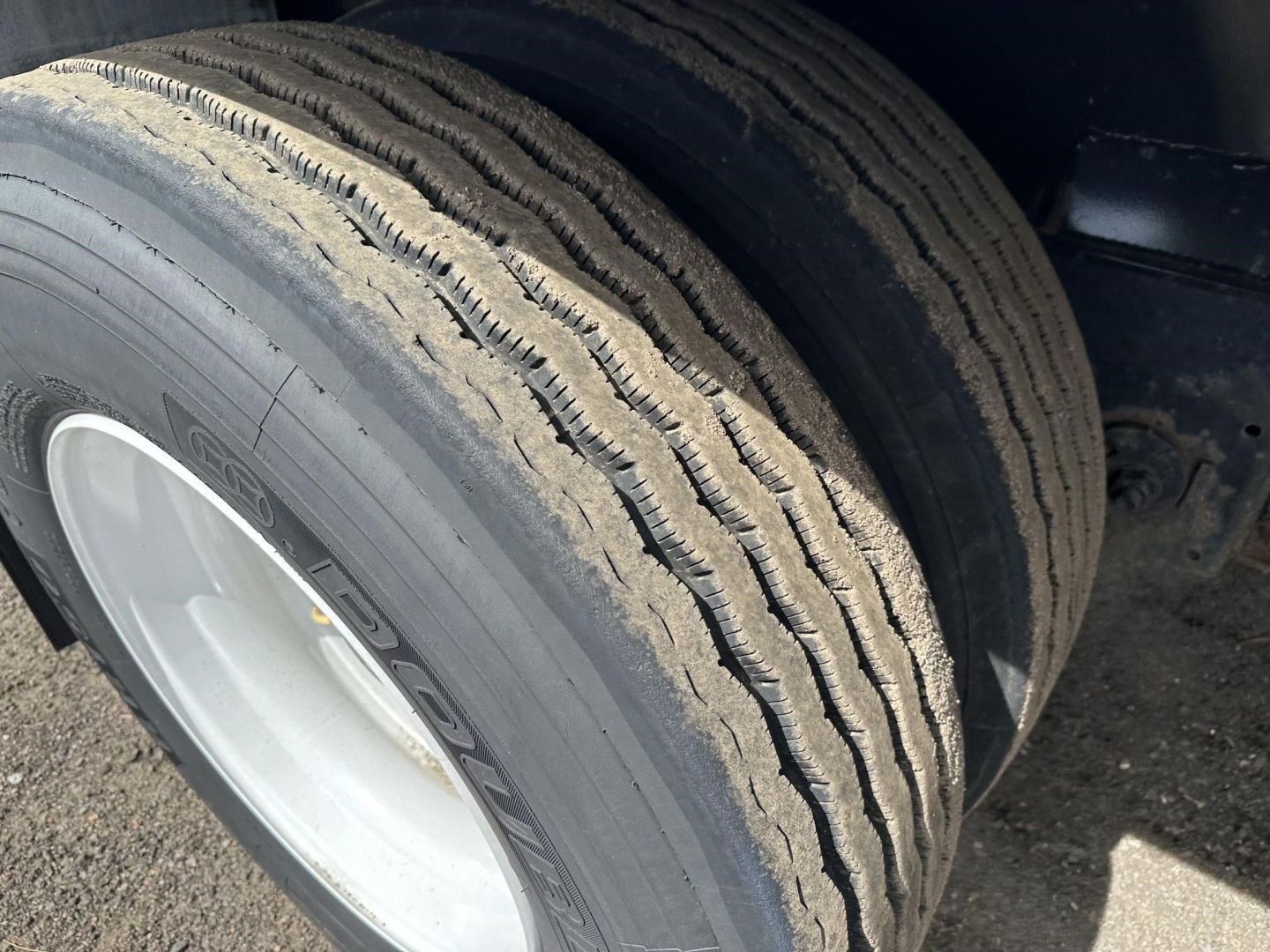 Truck trailer wheel and tire on Fontaine spread air combo flatbed showing dual tires with tread and rim.