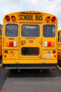 School bus rear showing emergency exit with 358, two red taillights, 'SCHOOL BUS' sign, and emergency door.