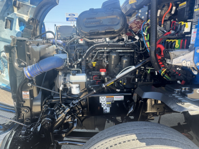 Kenworth T680 engine bay showing diesel engine components and hoses.