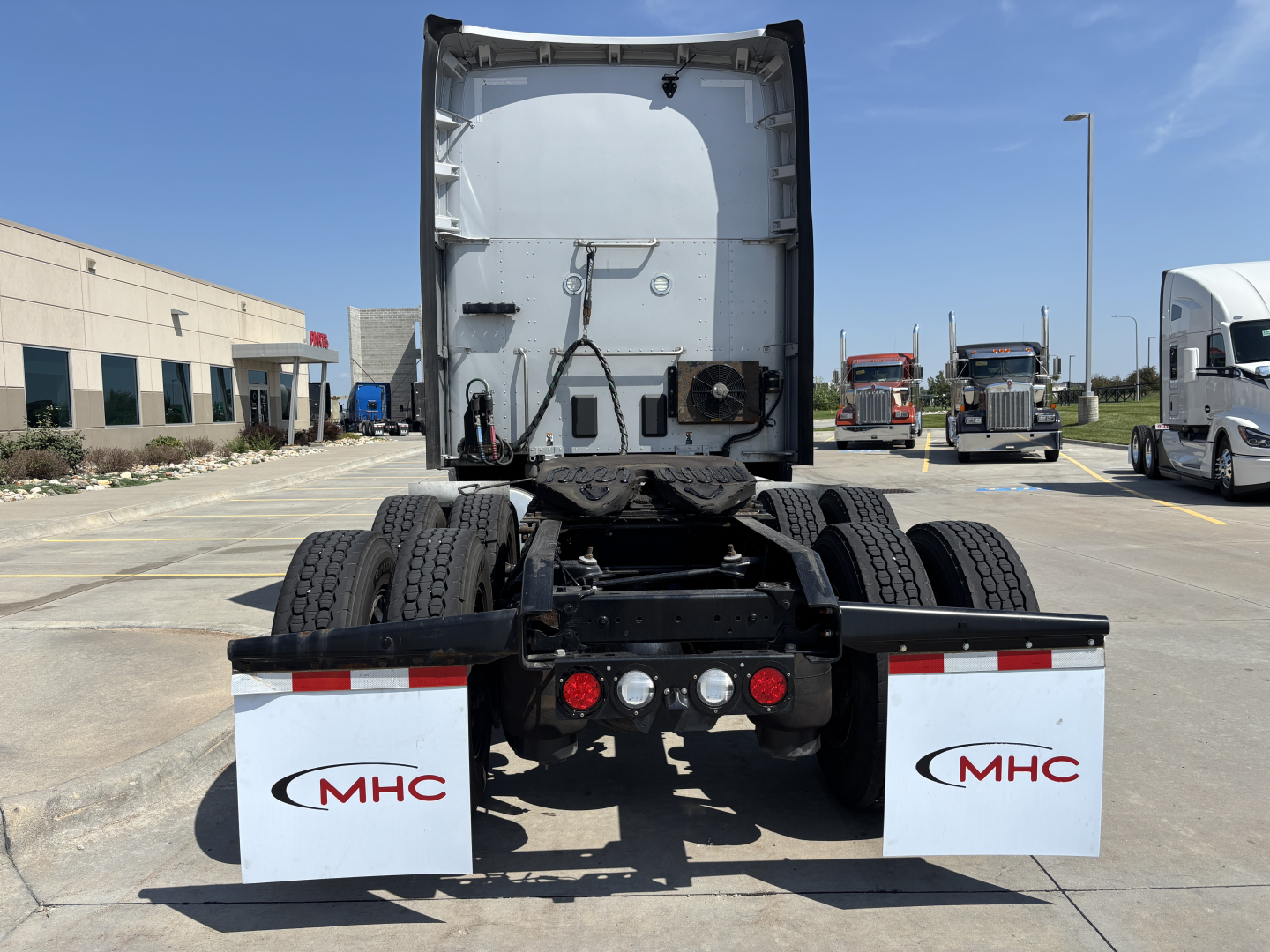 Kenworth T680 truck rear view showing fifth wheel, dual rear axles, mud flaps with MHC logo, and exhaust area; VIN and stock details not visible in image