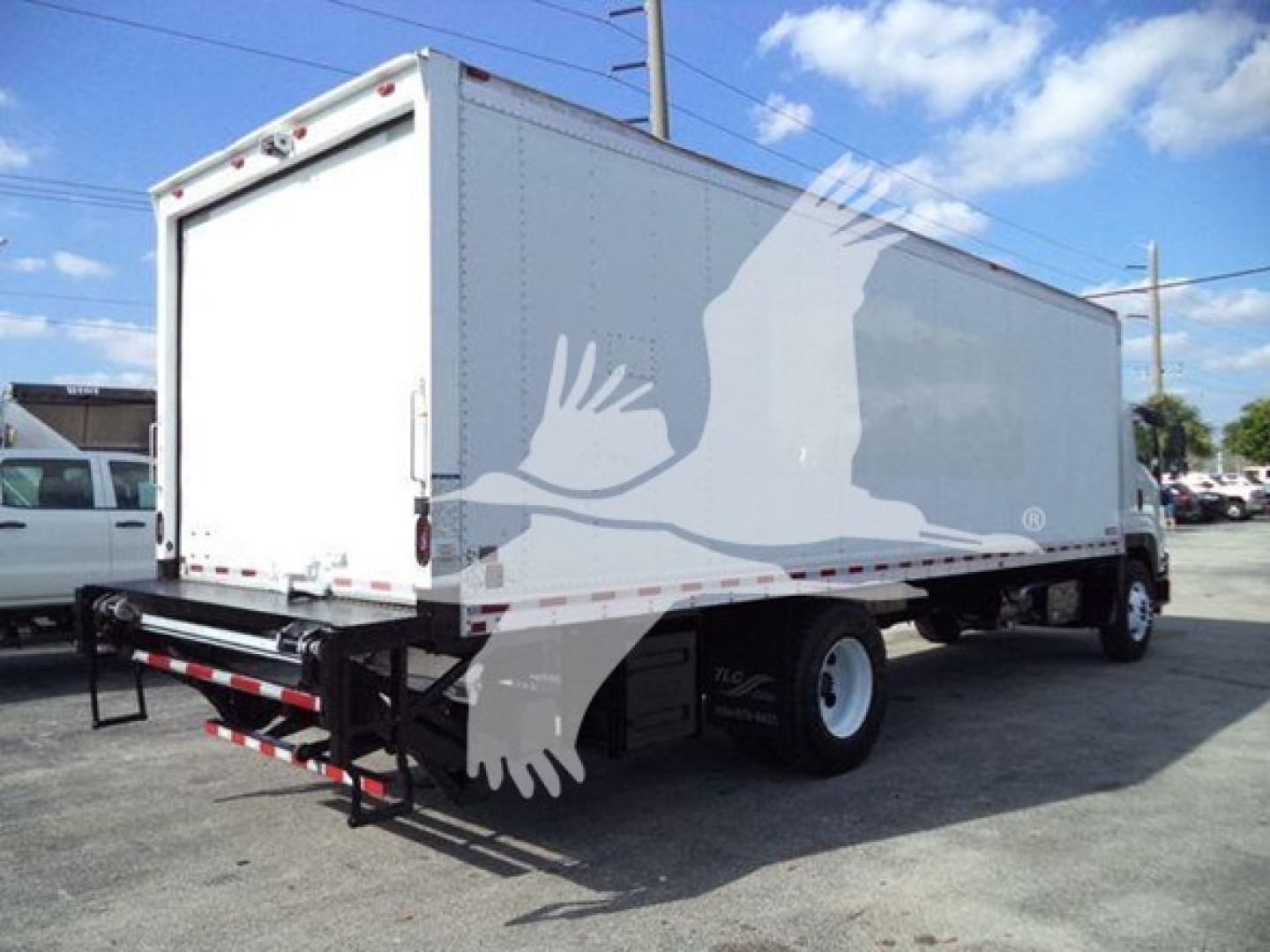 Isuzu FTR box truck rear view showing cargo area, rear bumper, and side profile; stock number T00818 visible.