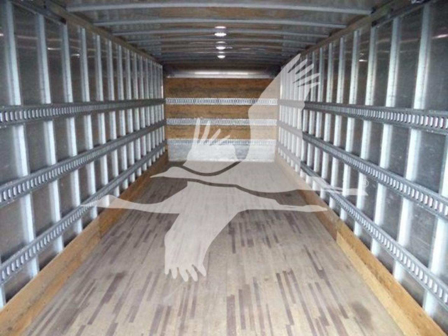 Isuzu truck box interior showing metal side rails and wooden floor. No visible text or labels readable inside the cargo area.