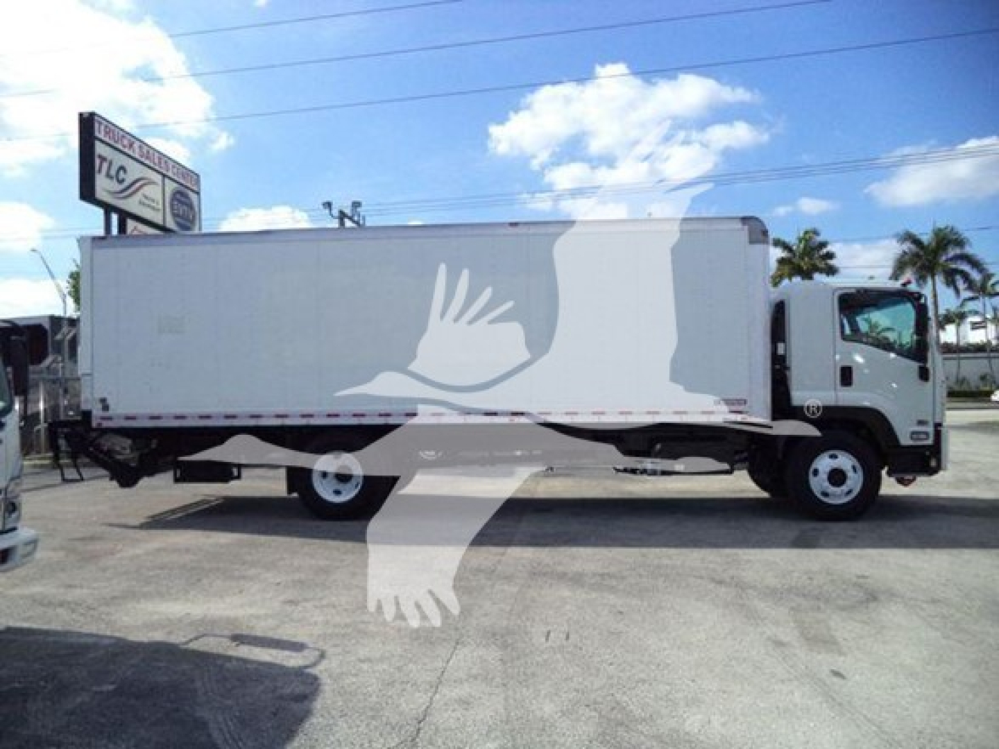 Isuzu box truck side view showing large white cargo box and cab with trailer hitch, no visible text on body.