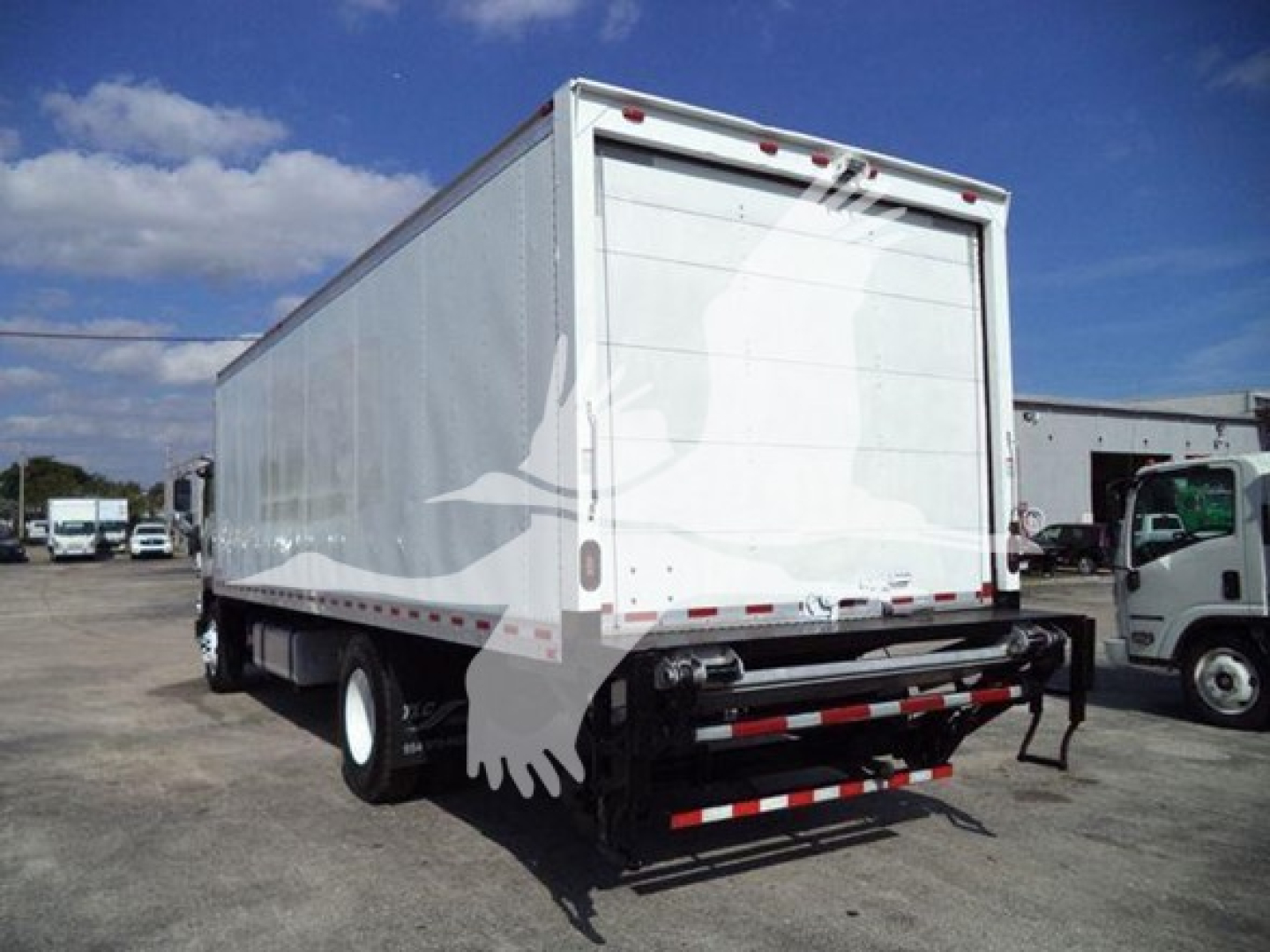 Isuzu box truck rear view showing large white box body and rear step bumper.