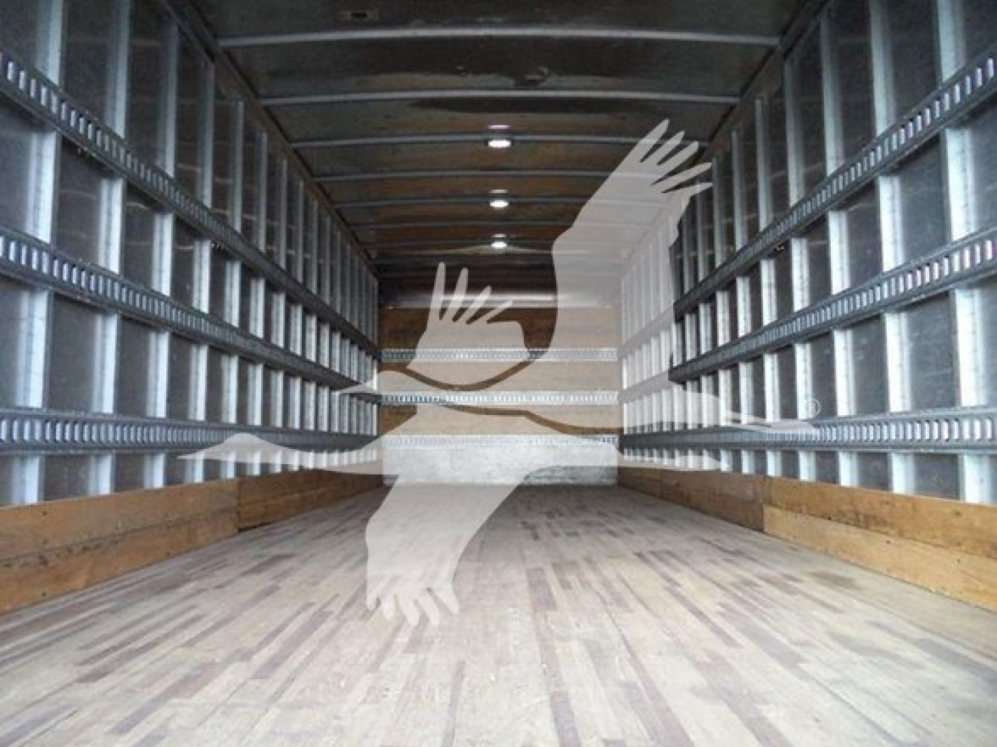 Interior of a box truck trailer showing empty cargo area with wooden floor and metal side rails.