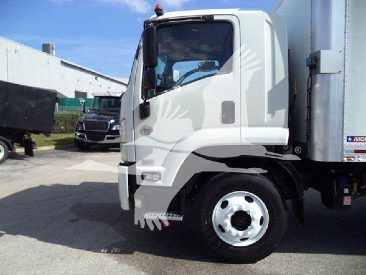 Isuzu FTR truck side view showing cab and front wheel with box body.