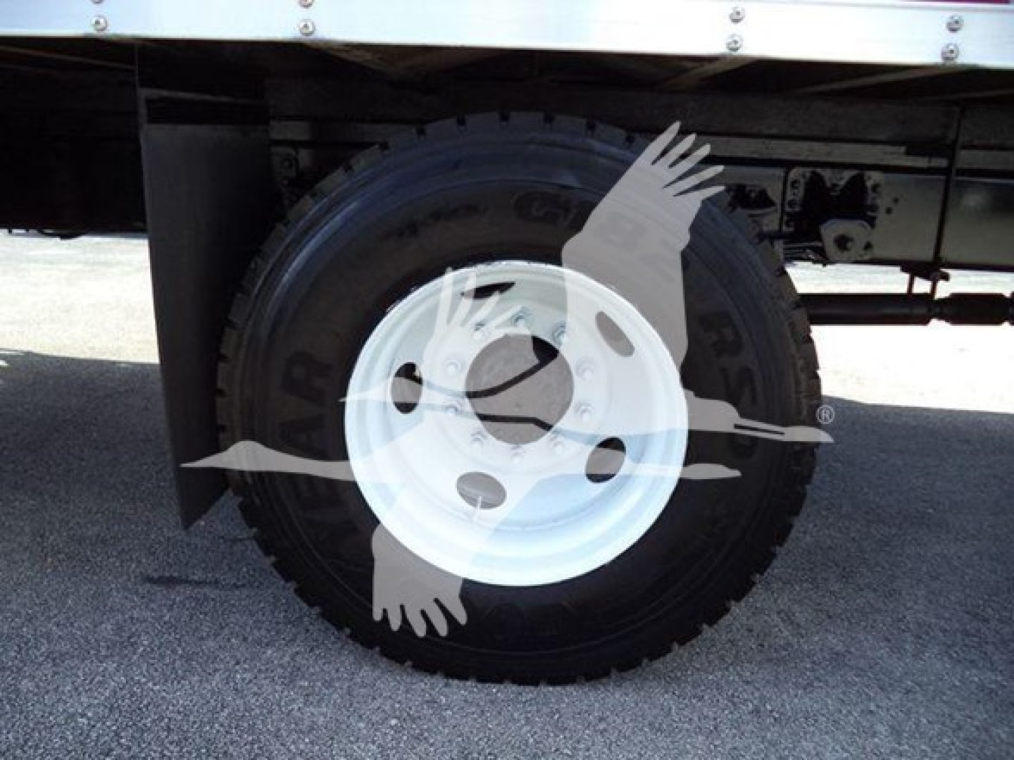 Isuzu box truck wheel and fender with white steel rim and tire showing standard hub, part of a box truck chassis.