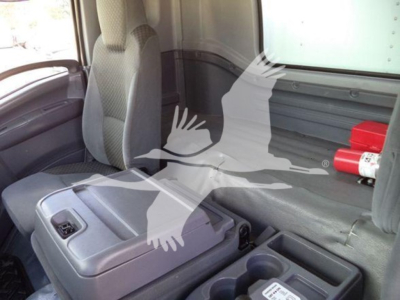 Isuzu FTR cab interior showing gray seats and center console, with storage bins and cup holders in view.