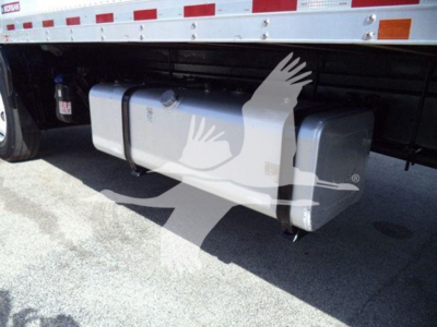 Isuzu FTR truck undercarriage showing a large rectangular aluminum fuel tank or underbody storage tank mounted to chassis with mounting straps and a blue-fluid reservoir nearby.
