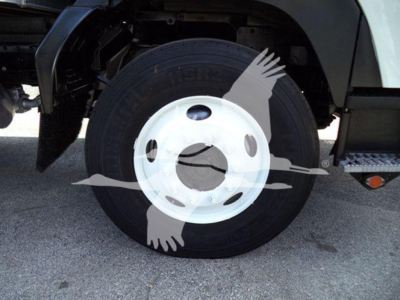 Isuzu FTR wheel and tire with white steel rim and black tire; part of box truck undercarriage visible.