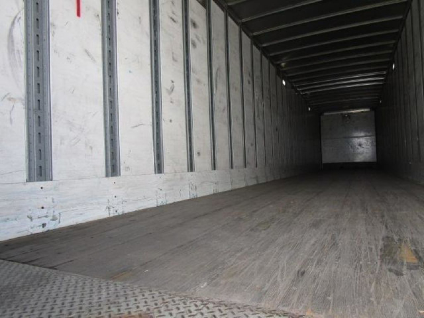 Interior of a Stoughton van trailer with wooden floor and metal interior, empty cargo space.