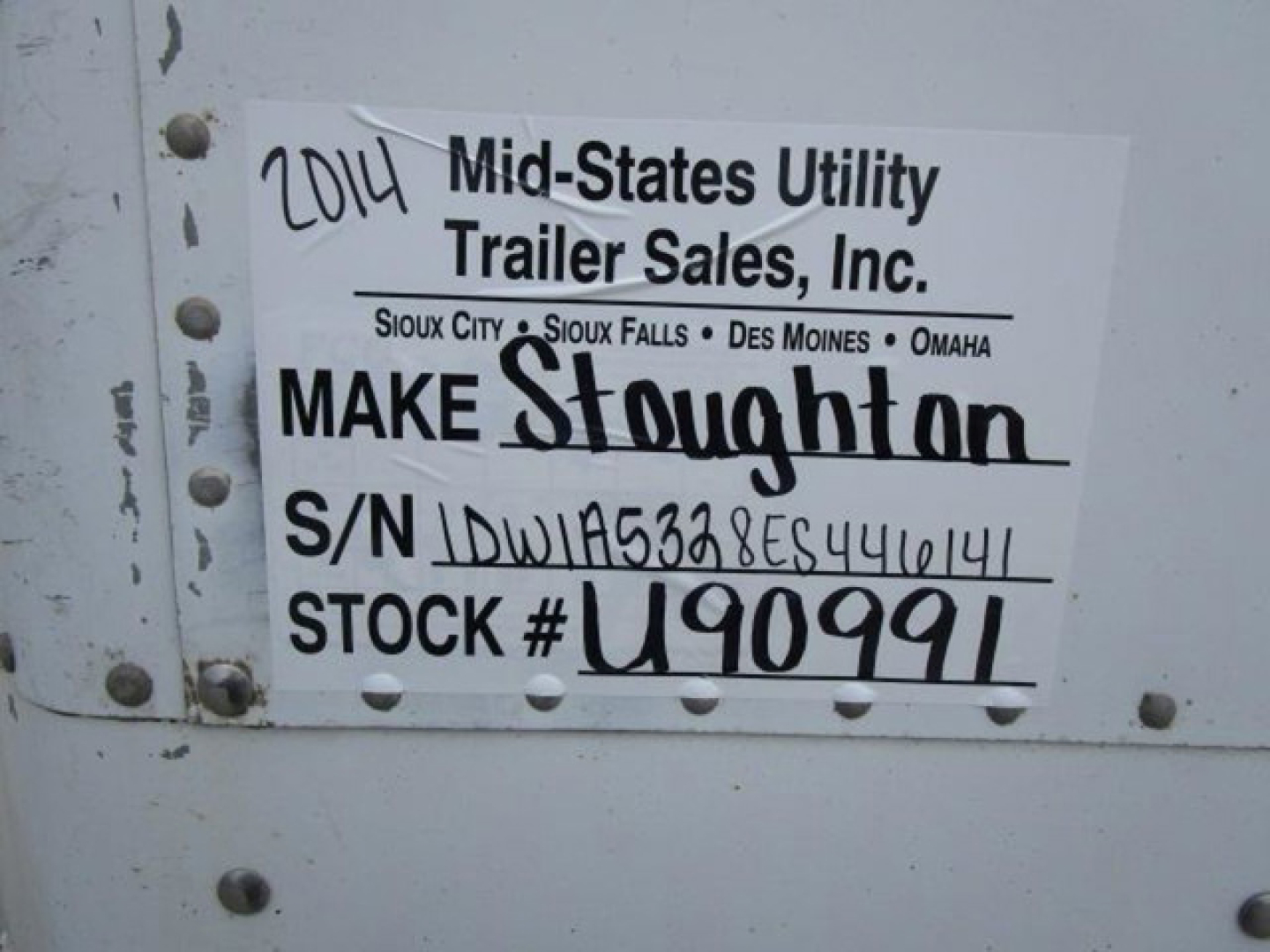 Trailer side showing white label with handwritten and printed text: '2014 Mid-States Utility Trailer Sales, Inc.' and 'S/N IDW... STOCK # U90991'