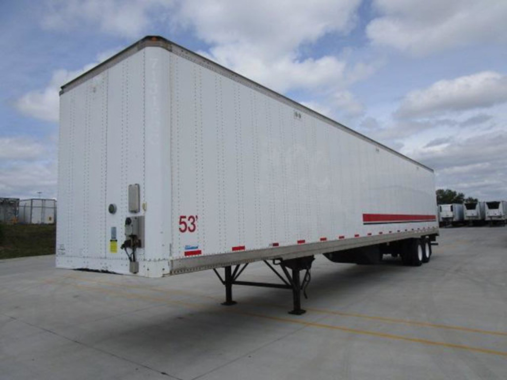 Stoughton van trailer in a parking lot, white exterior, 53' length, gooseneck-style support dually wheels under midline, side red reflective markings, VIN plate and rear doors visible.