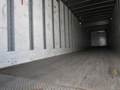 Interior of a Stoughton van trailer with wooden floor and metal interior, empty cargo space.