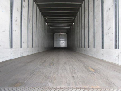 Trailer interior showing empty cargo area with wooden floor and metal side rails in a Stoughton van.