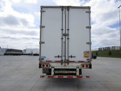 Rear view of a white 2014 Stoughton van trailer with double doors, stock U90991, VIN partially visible, in a truck yard.