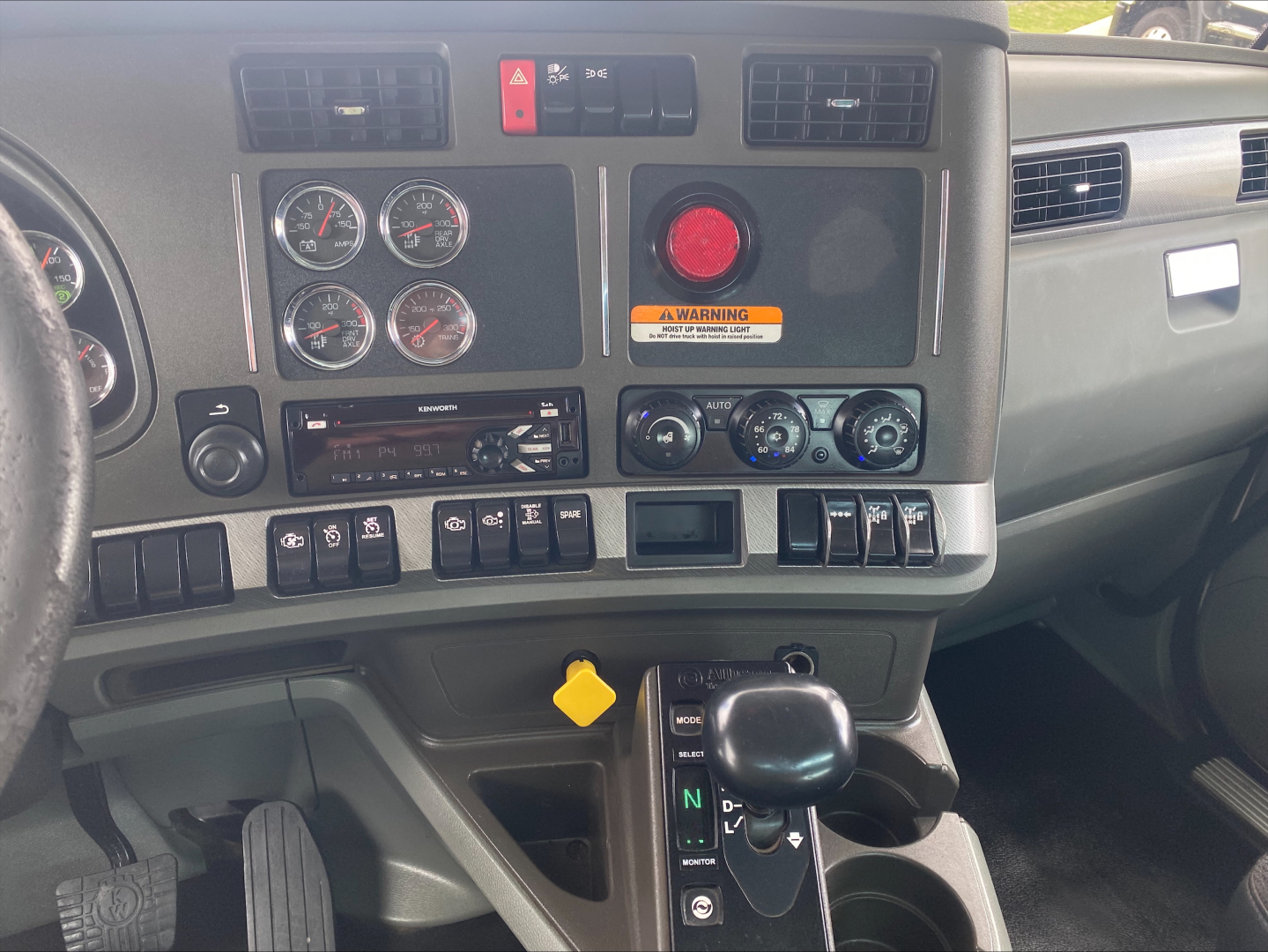 Kenworth T880 truck interior dashboard with gauges, air controls, and gear shifter visible.