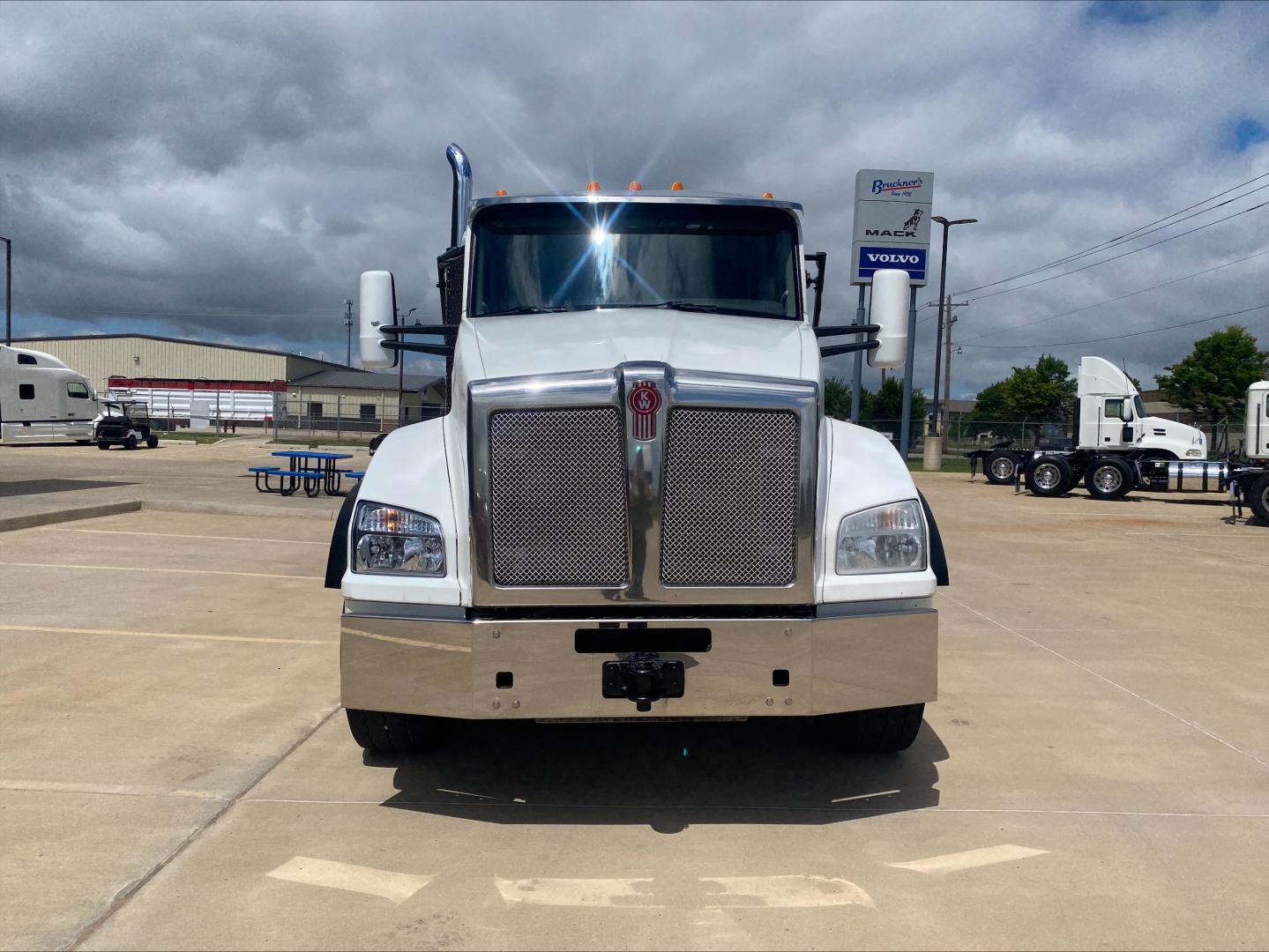 Kenworth T880 front view showing large mesh grille, chrome bumper, and dual rectangular headlights.