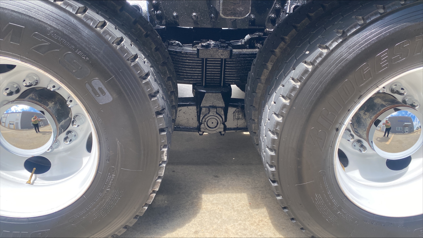 Dual Kenworth T880 truck wheels and hitch area, view of rear axle and suspension undercarriage.