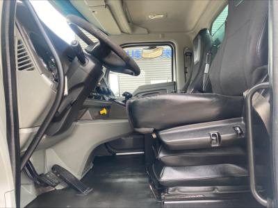 Cab interior of a 2018 Kenworth T880 rolloff truck showing driver's seat, steering wheel, and dashboard with visible controls and pedals.