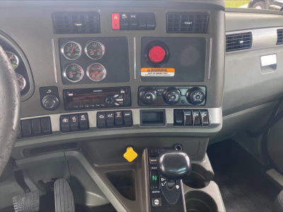 Kenworth T880 truck interior dashboard with gauges, air controls, and gear shifter visible.