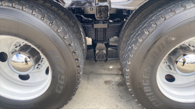 Kenworth T880 truck dual rear wheels showing drivetrain and suspension components between tires.