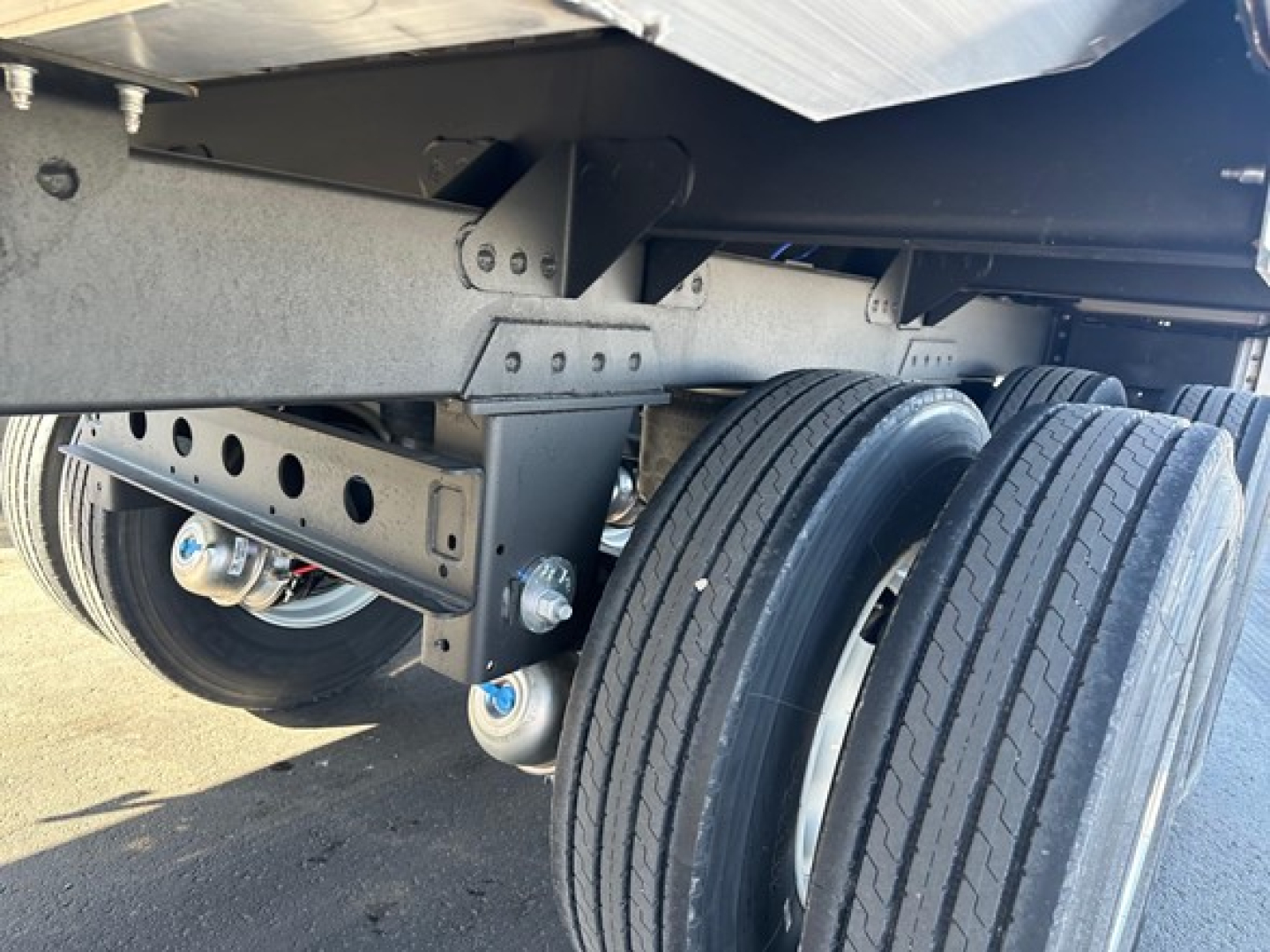 Trailer axle assembly showing dual rear tires and suspension brackets under a 2026 Timpte hopper trailer.