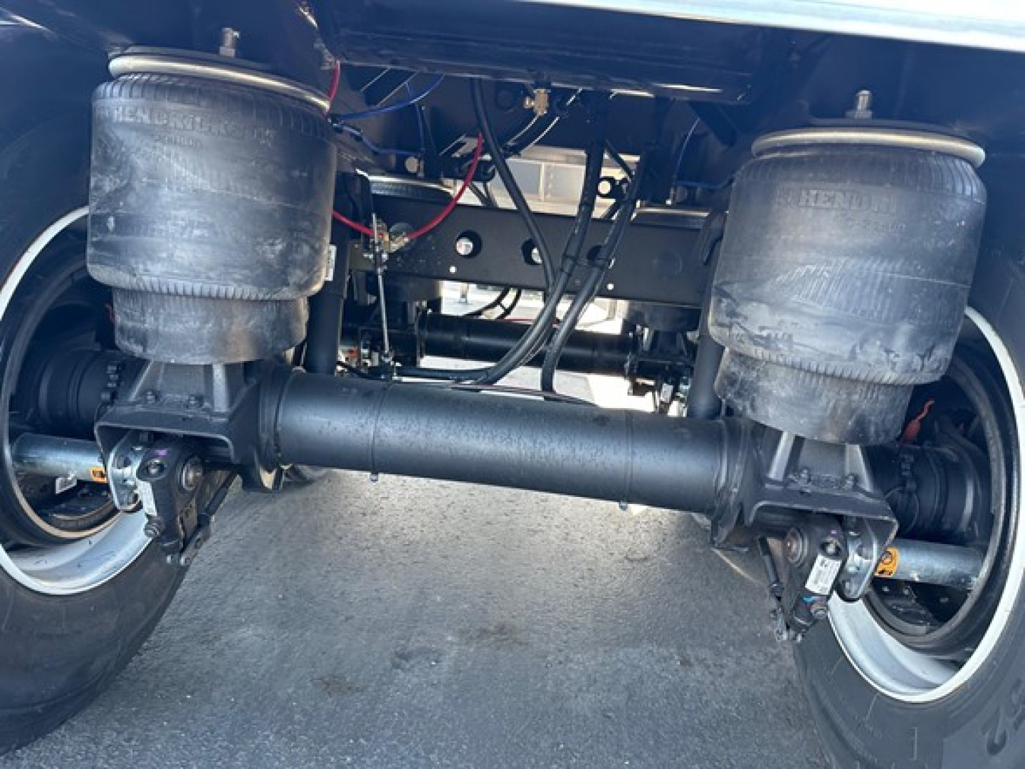 Timpte Super Hopper undercarriage showing air suspension bags, steel axle beam, and drive components.