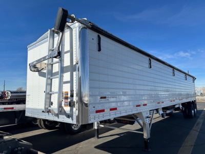 Timpte Super Hopper W trailer side with ladder at front, aluminum hull, dual rear wheels, reflective side markers.