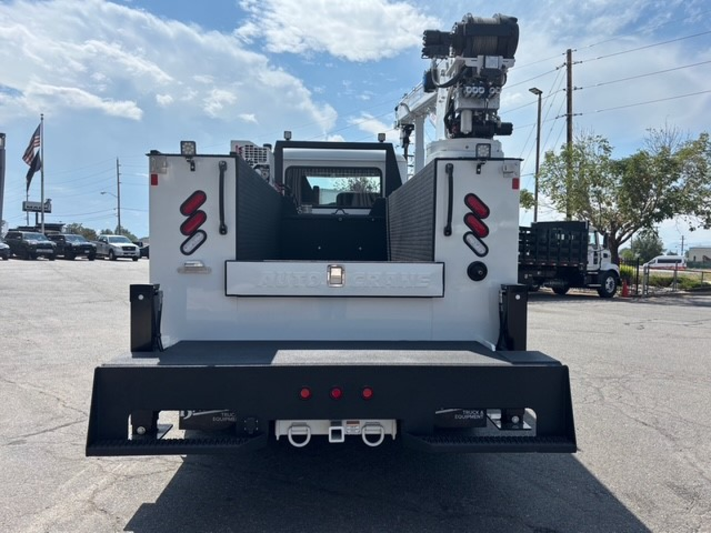 Mack MD6 service truck rear showing tow hitch, hydraulic crane, and tail lights.