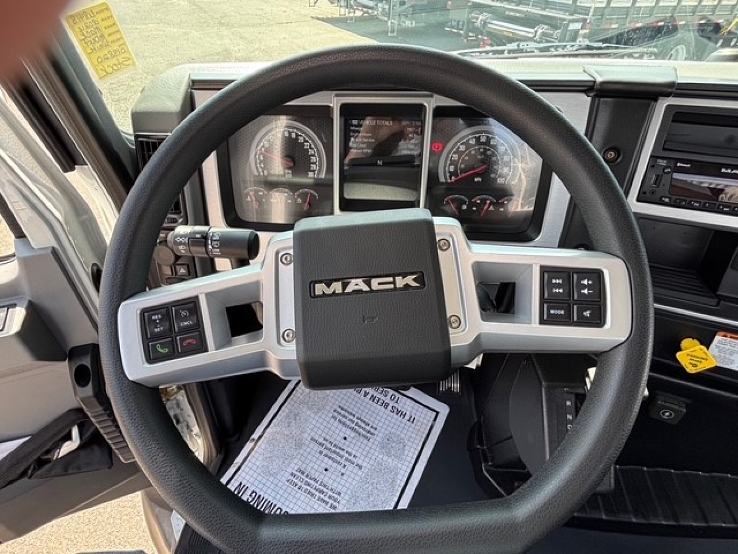 Mack MD6 steering wheel and dashboard with instrument cluster and controls visible.