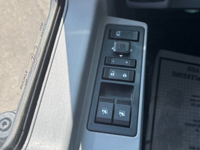 Control panel with window/lock switches inside a Mack MD6 truck cab, showing multiple button symbols and a dial near a door frame.