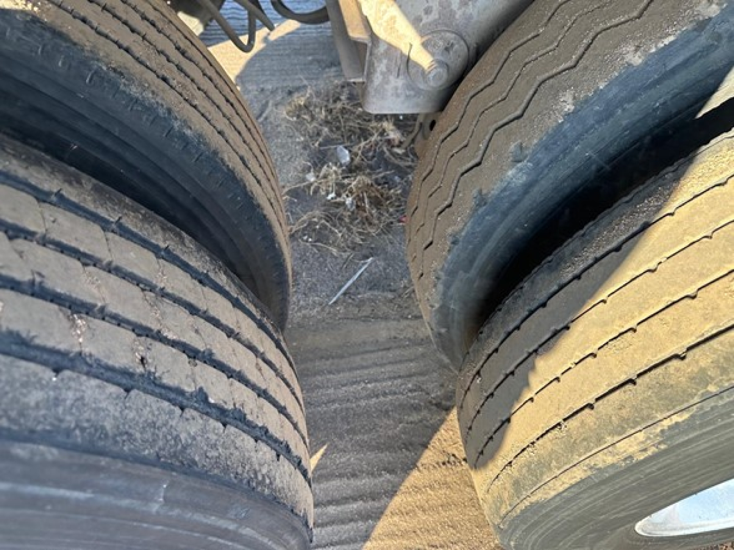 Trailer wheel tires side-by-side shows tread and wear lines on dual axles, part of Heil pneumatic trailer undercarriage.