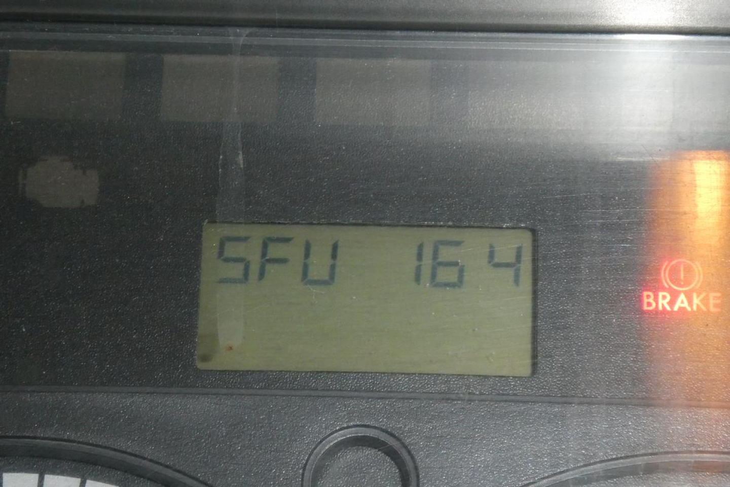 Dashboard display showing SFU 164 and a brake indicator on Freightliner Cascadia 113 cab/console.