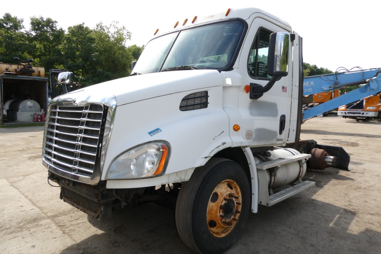Truck front-left view showing Freightliner grille with side mirror and headlight; cab badge; front fender; wheel with exposed hub; no trailer attached.