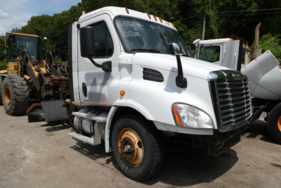 Truck: 2011 Freightliner Cascadia 113 daycab, white cab, side view, VIN 1FUBGADV1BSAV4622, stock 0521233, used condition with front single sleeper and cargo equipment in background.