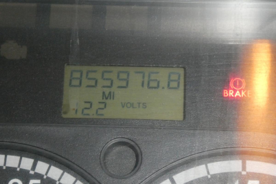 Dashboard odometer reading 855,976.8 miles with 12.2 volts, brake warning light visible on Freightliner Cascadia dash.