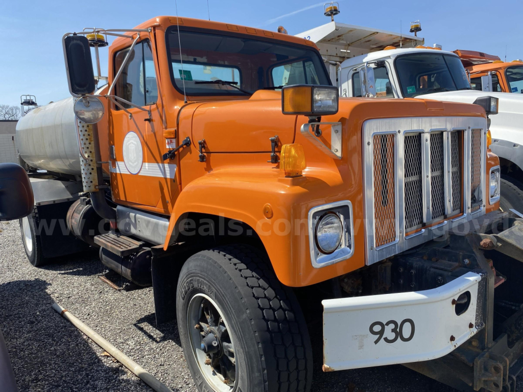 Orange International heavy-duty truck cab front quarter view showing large grille, bumper with 930 number, side mirrors, and dual headlights.