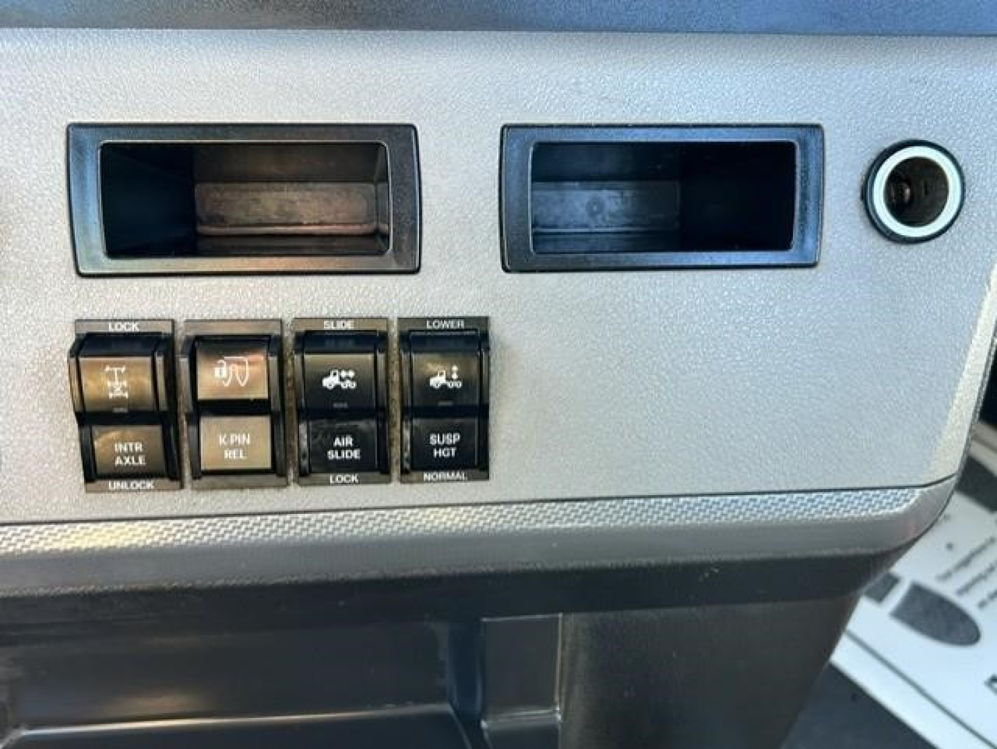 Dashboard controls and switches of a Freightliner Cascadia 126 day cab showing various labeled switches and blank slots.