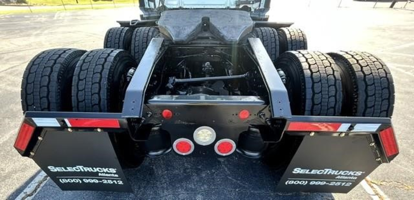 Freightliner Cascadia 126 rear view showing dual rear axles, fifth wheel mount, dual mudflaps with SelectTrucks branding and contact numbers.