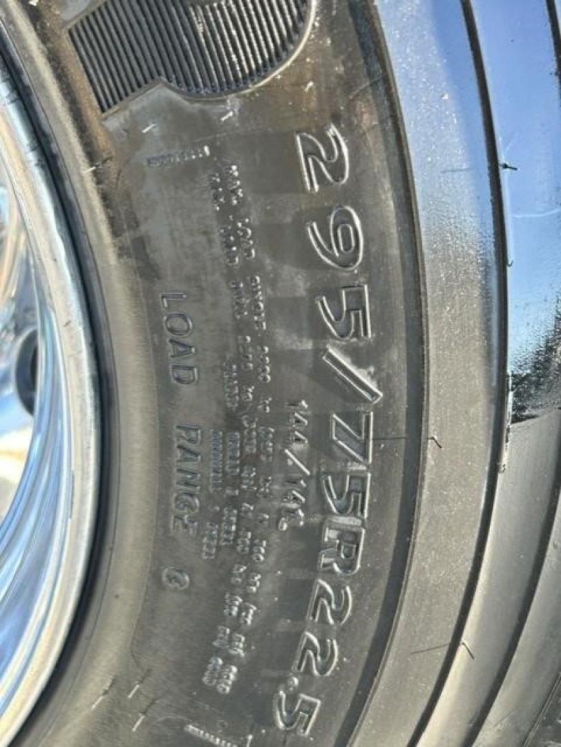 Wheel and tire sidewall with visible tire size 295/75R22.5 and load range markings for a Freightliner Cascadia 126 truck.