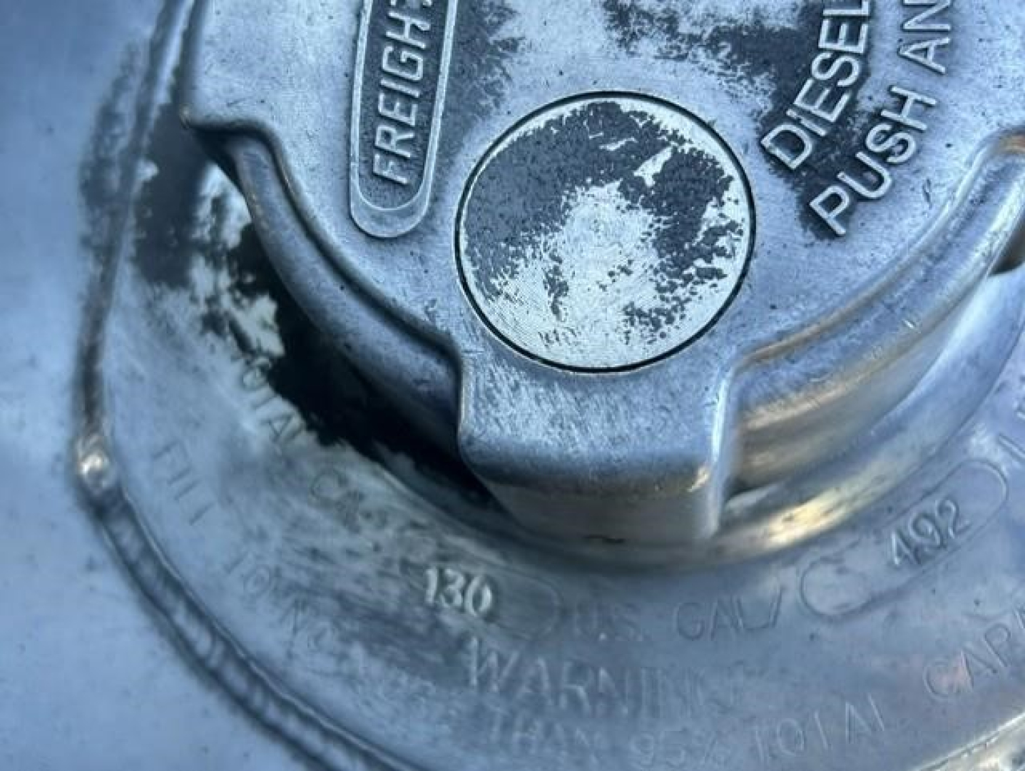 Cap with 'Freightliner' emblem and diesel push button, circular gauge area visible