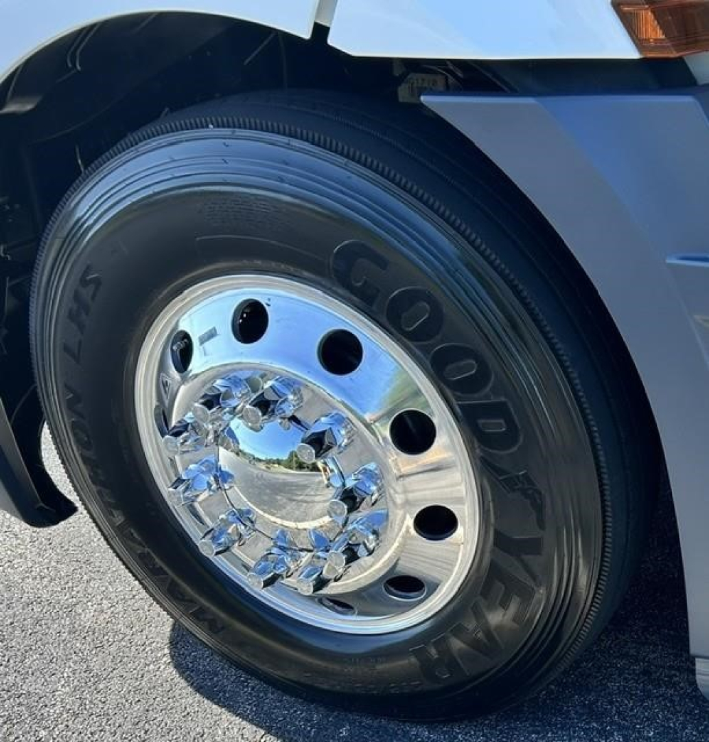 Goodyear Goodyear tire on Freightliner Cascadia front wheel showing polished chrome hubcap and wheel with multiple circular holes.