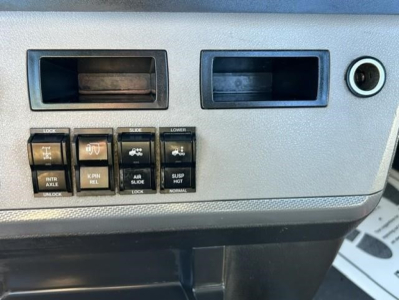 Dashboard controls and switches of a Freightliner Cascadia 126 day cab showing various labeled switches and blank slots.