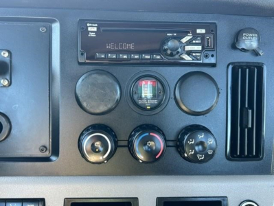 Dashboard panel of a 2021 Freightliner Cascadia 126 truck showing a CD/Radio head unit, three circular gauges, a def/aux switch, and an engine controls area.