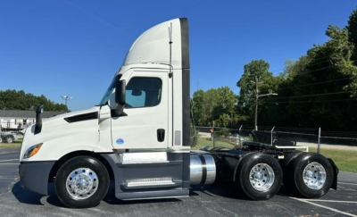 Freightliner Cascadia 126 day cab truck side view showing sleeper cab, chrome wheels, and dual rear axles.