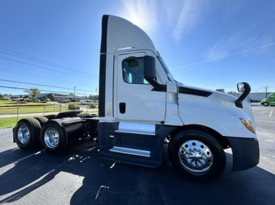 Truck-side view of a 2021 Freightliner Cascadia 126 day cab with white exterior and chrome wheels.