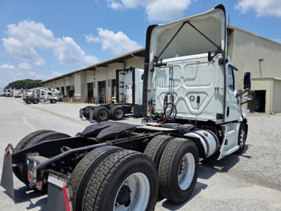 2020 Freightliner Cascadia126 conventional daycab truck chassis shown from rear quarter with open cab area.